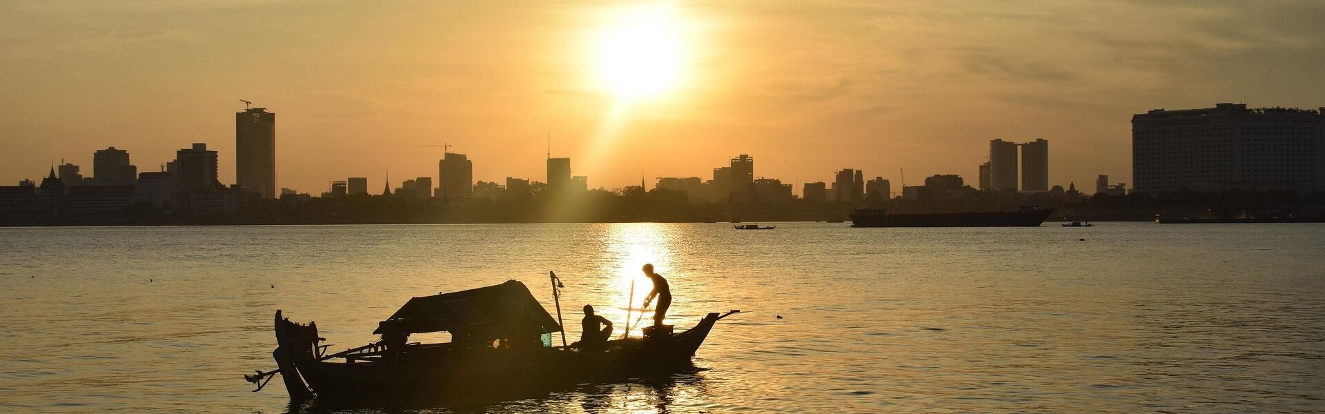 Phnom Penh’s vibrant Mekong skyline at dusk on a Phnom Penh Travel banner by Legend Travel Group.